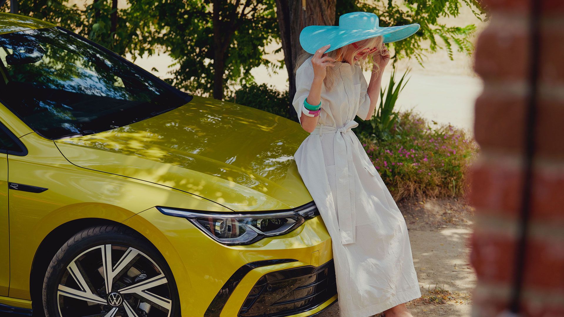 VW Golf Frontansicht, Frau sitz auf der Motorhabe
