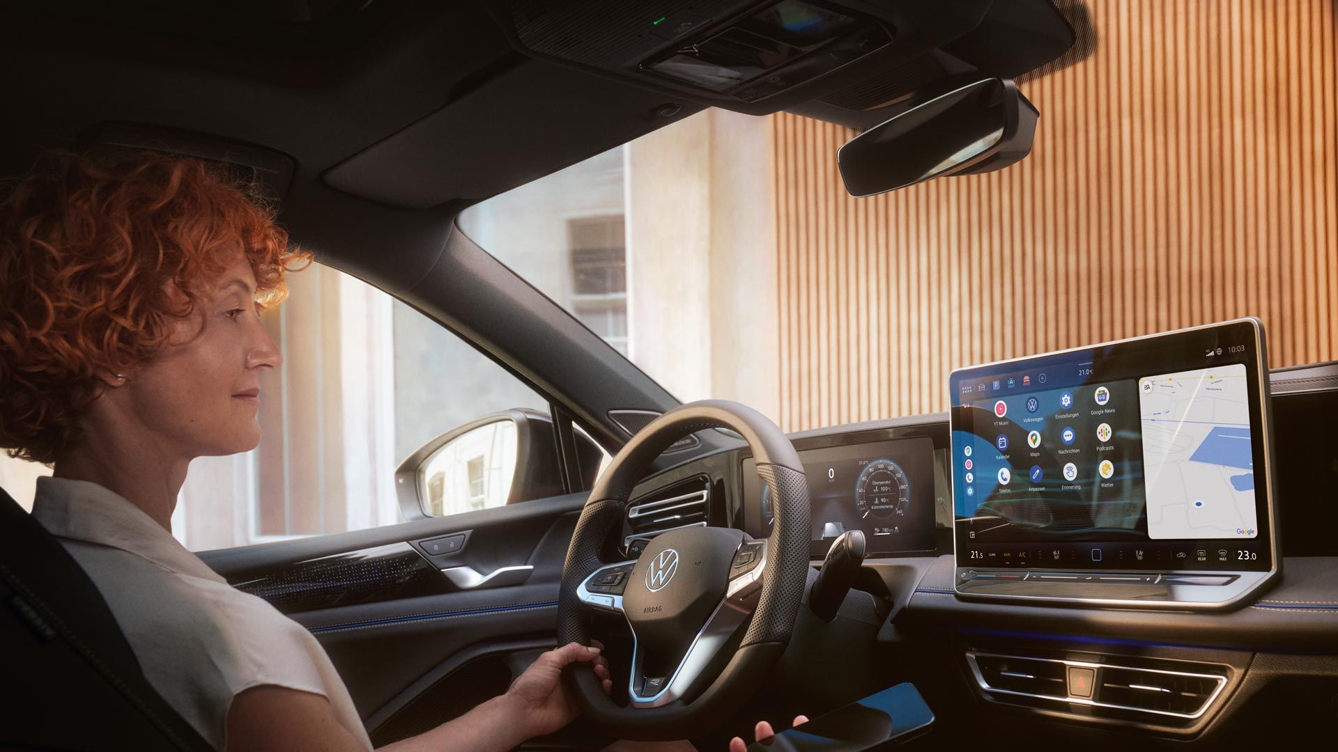 Eine Frau sitzt am Steuer des VW Passat in Interaktion mit der optionalen App-Connect und ihrem Smartphone.