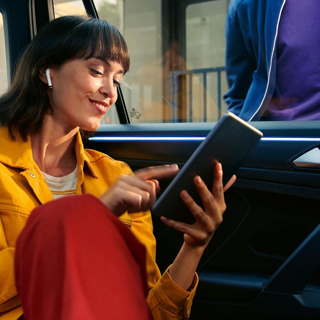 Žena koristi tablet na zadnjem sedištu automobila