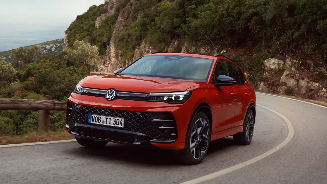 Roter VW Tiguan fährt eine kurvige Straße entlang.