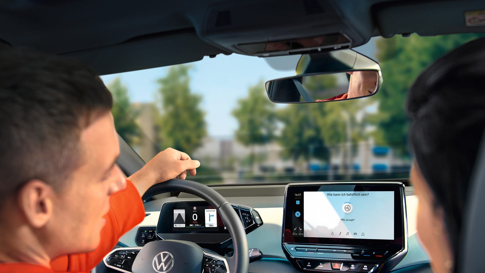 Fahrer nutzt Sprachbedienung im VW ID.3, Ansicht von hinten ins Cockpit