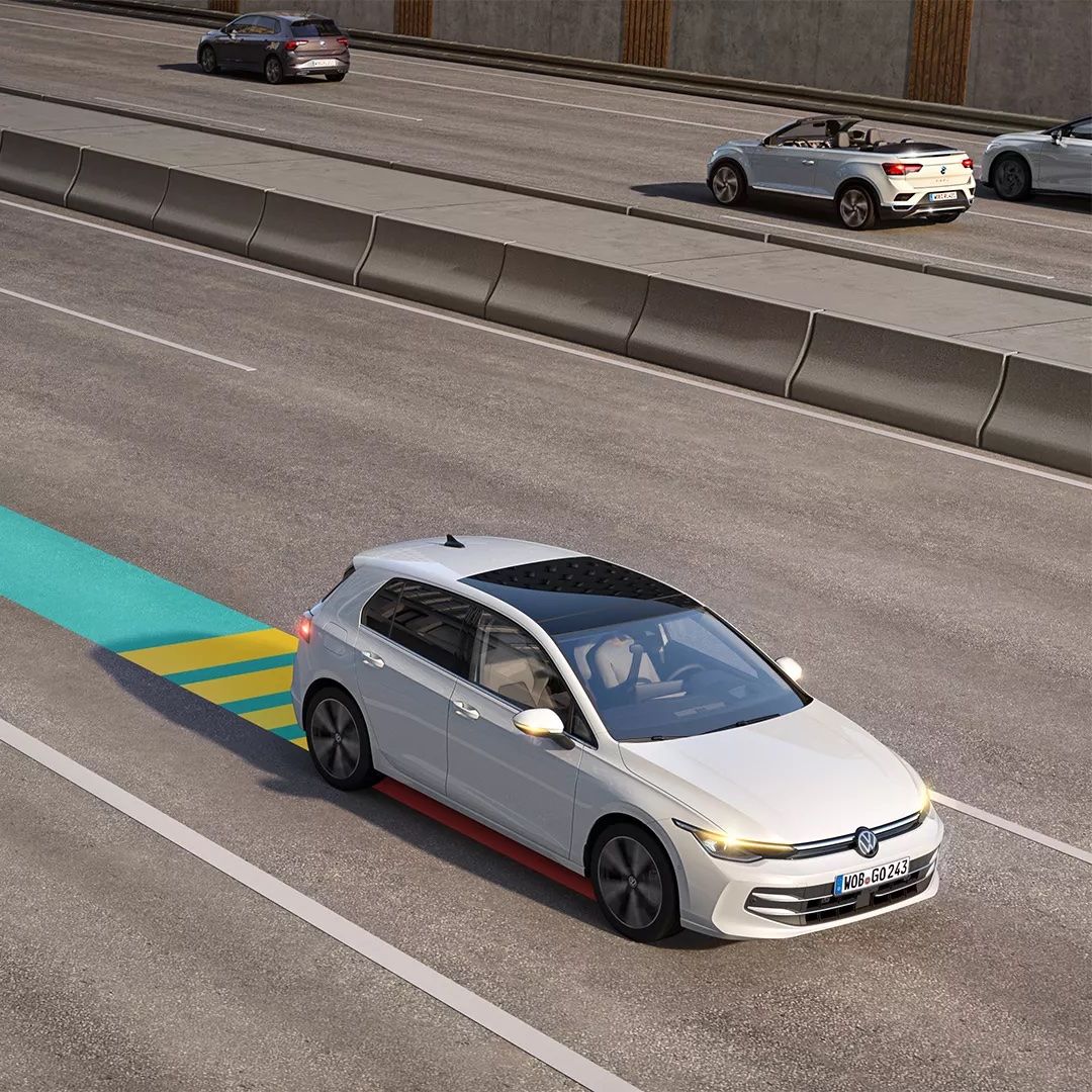 Weißer VW Golf bewegt sich im Straßenverkehr, dabei wird der Emergency Assist genutzt und im Bild schematisch dargestellt.