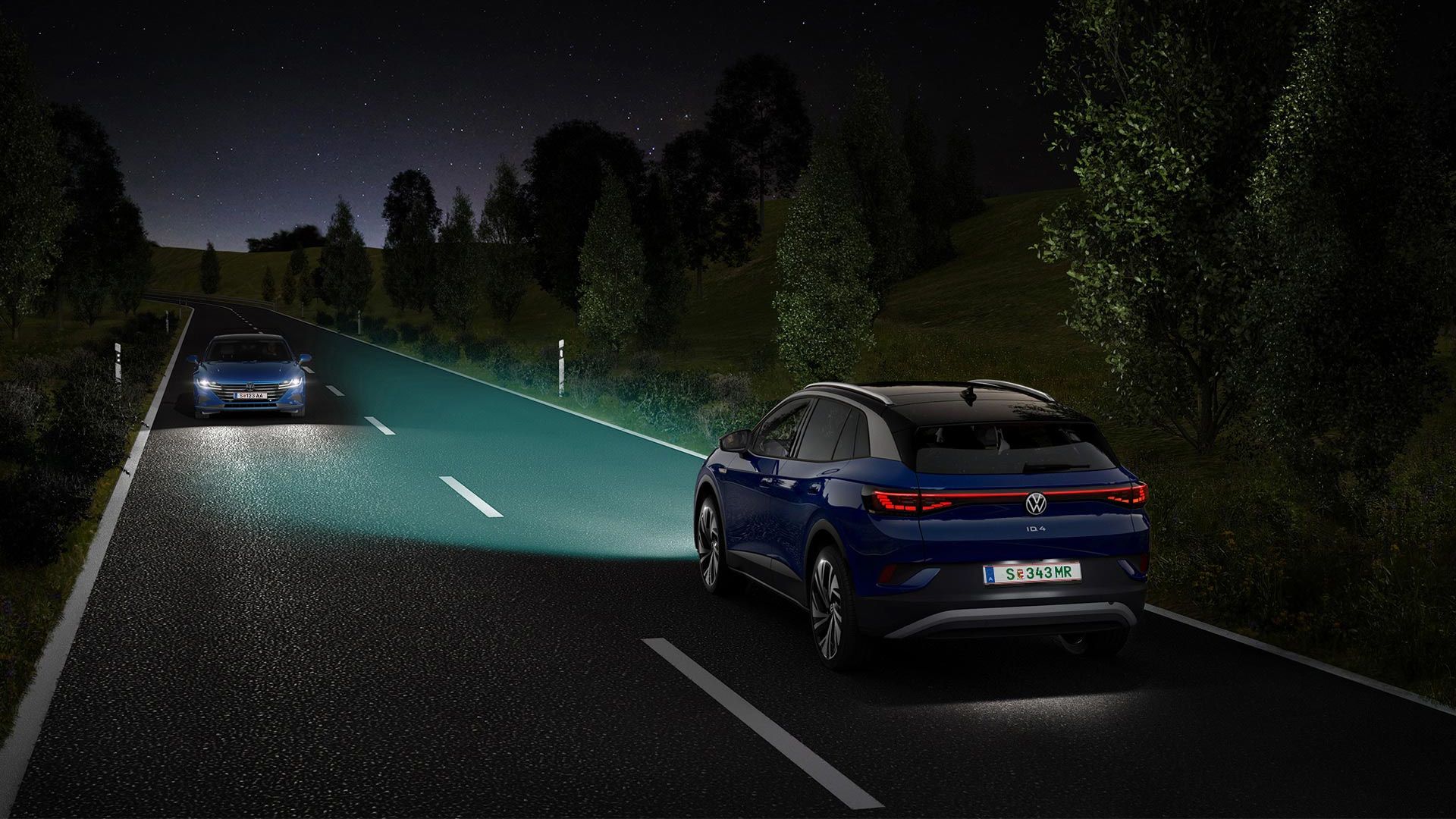 Ein blauer VW ID.4 fährt mit eingeschaltetem Licht eine nächtliche Straße entlang.