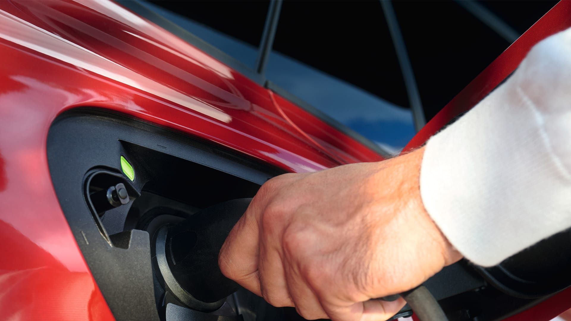 VW ID.5 GTX, Detailansicht der Ladedose, Hand schließt Stecker an