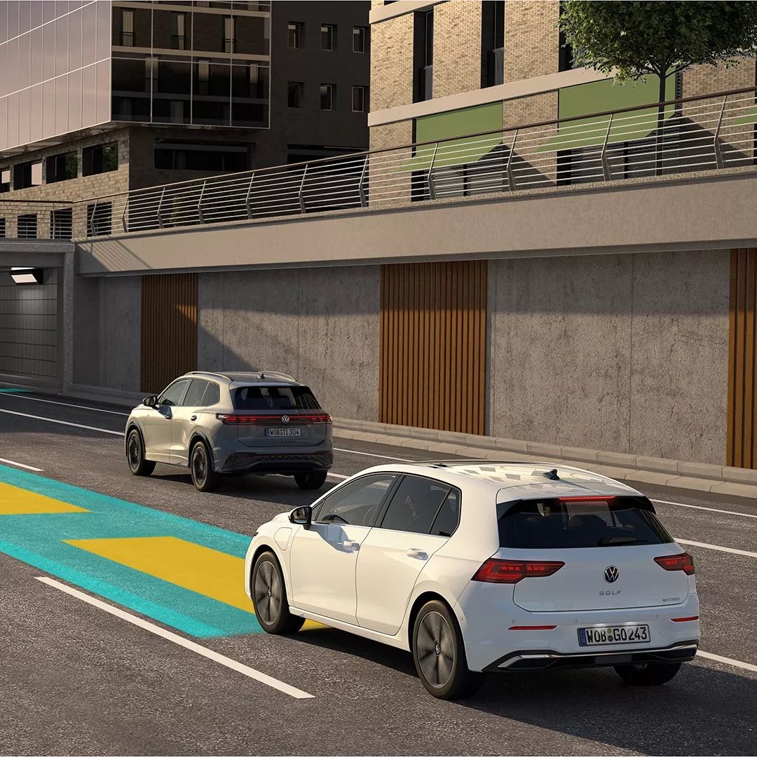 Weißer VW Golf bewegt sich im Straßenverkehr, dabei wird der optionale Travel Assist genutzt und im Bild schematisch dargestellt.