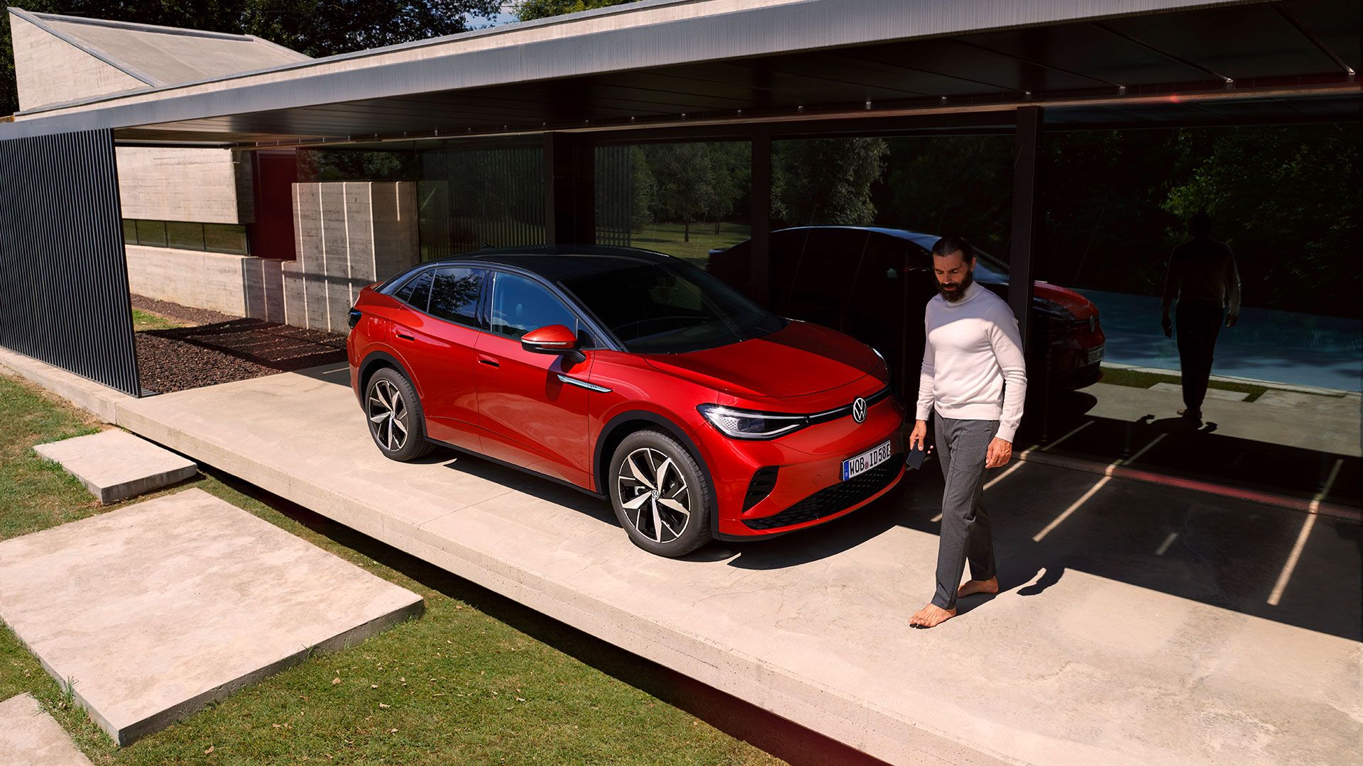 Roter VW ID.5 GTX parkend vor einem Haus. Ein Mann geht vorbei.