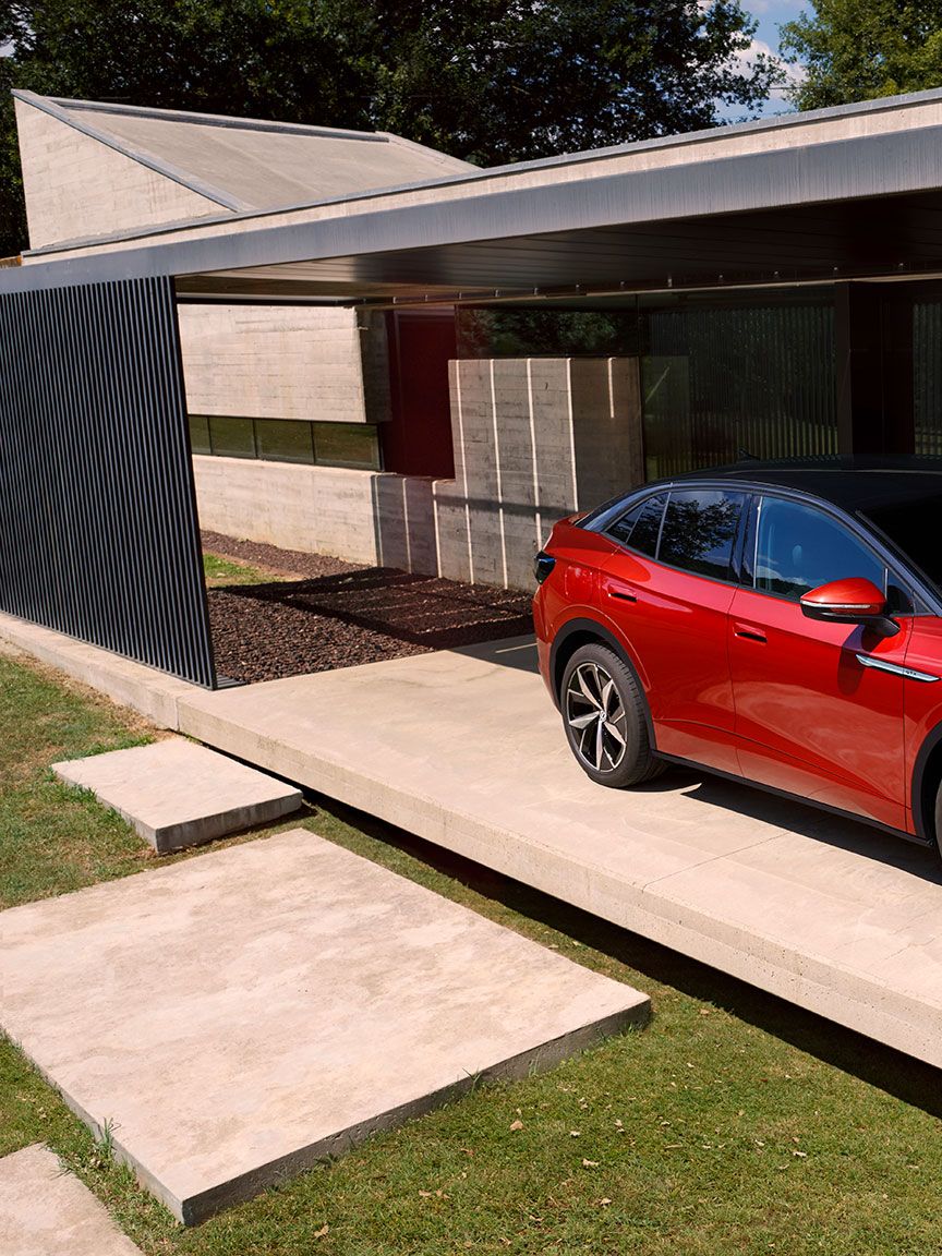 Roter VW ID.5 GTX parkend vor einem Haus. Ein Mann geht vorbei.
