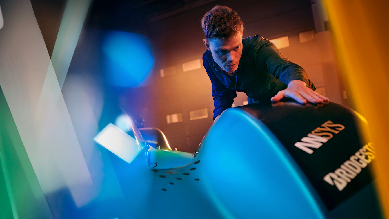 Ein junger Mann, Fotomodell, Aerodynamik, Volkswagen ID.R, elektrisch angetriebener Rennwagen, Lagerhalle