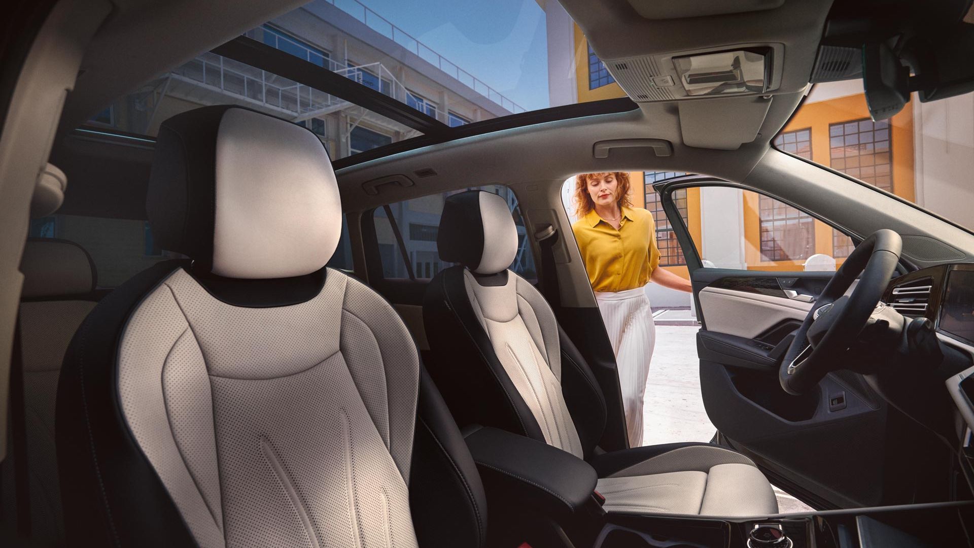 Innenschuss des VW Tiguan. Eine Frau steigt auf der Fahrerseite ein.