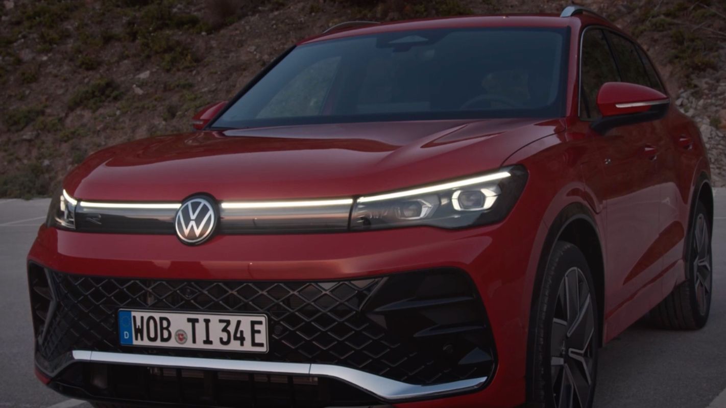 Detailansicht der Front-Lichtsignatur eines auf einem Parkplatz stehenden roten VW Tiguan.