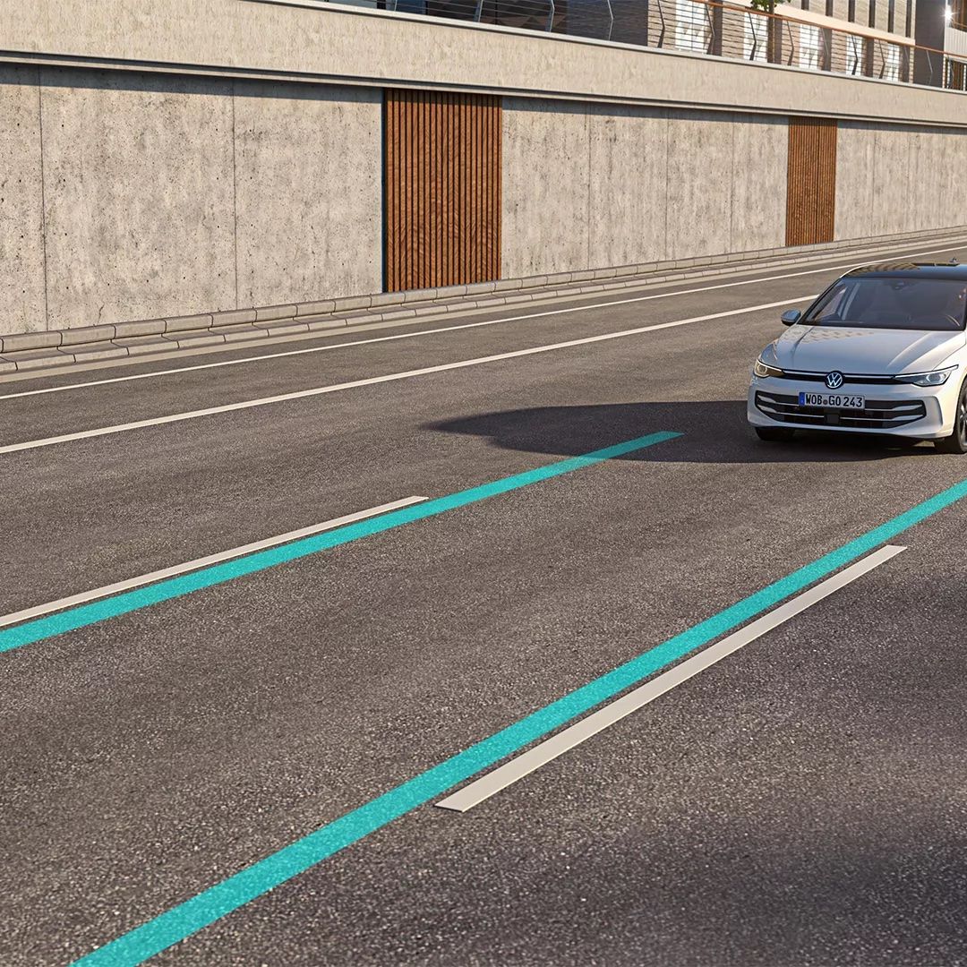 Ein weißer VW Golf nutzt den Lane Assist, um in der Spur zu bleiben.