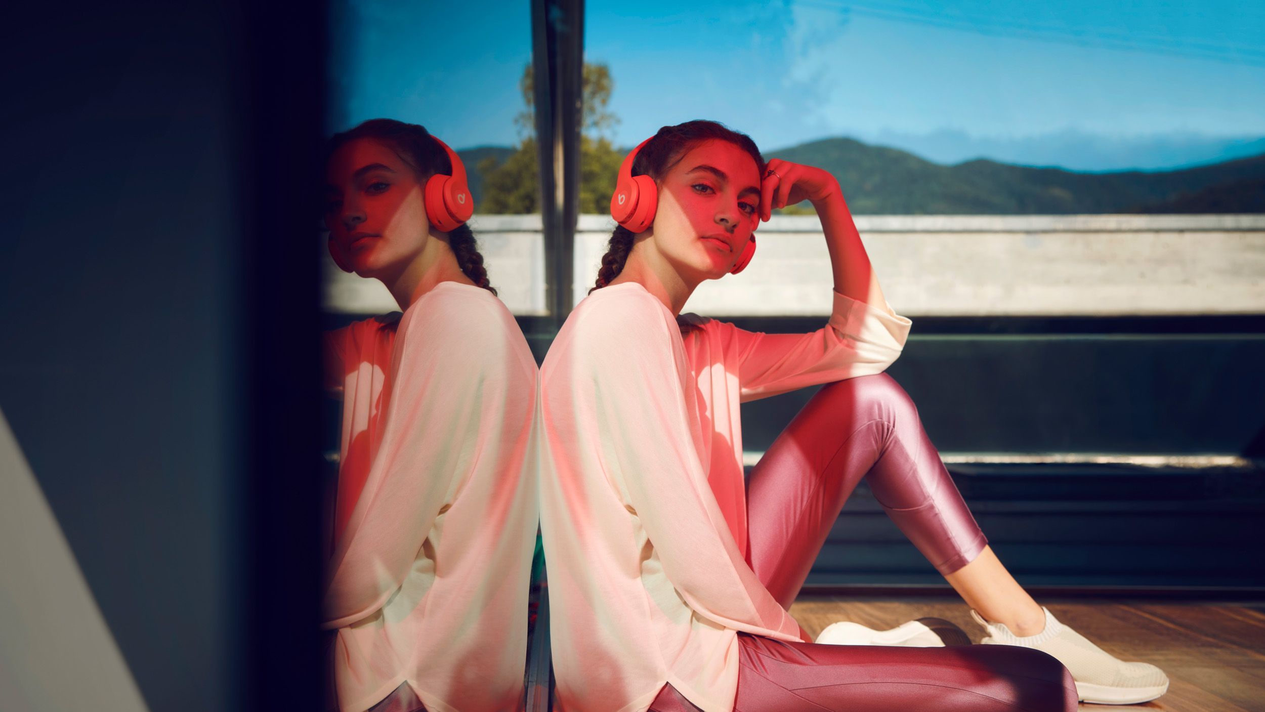 Model mit Kopfhörer vor einer Glasscheibe