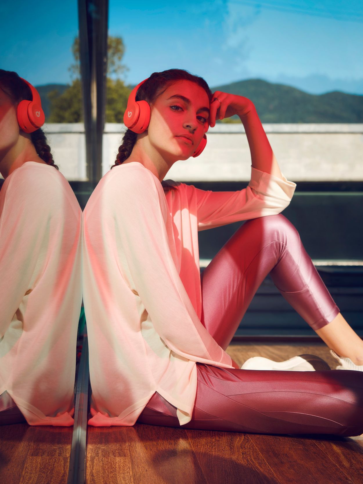 Model mit Kopfhörer vor einer Glasscheibe