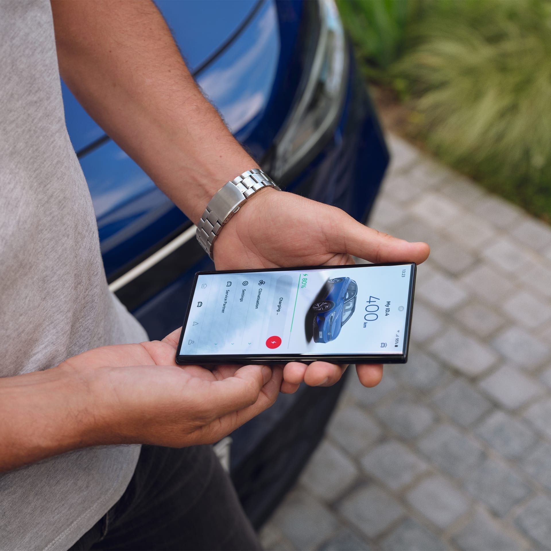 Detailansicht eines Mannes, der ein Smartphone in beiden Händen hält. Auf dem Display zu sehen die We Connect ID. App